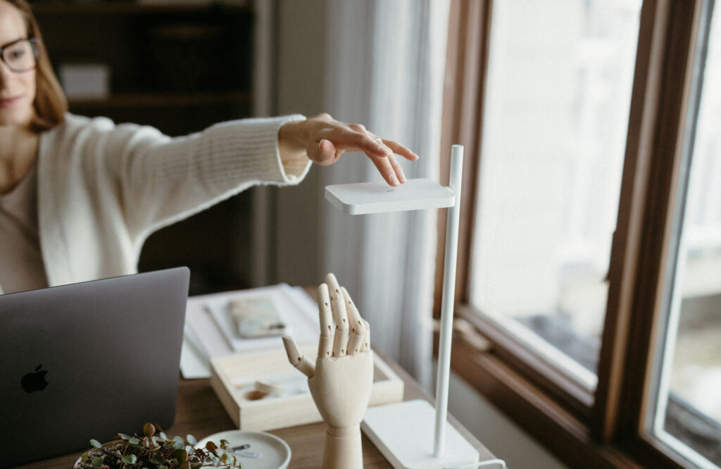 woman turning on a desk lamp for focus work